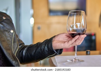 Man's Hand Holding A Glass Of Red Wine. Visit To A Winery In Mendoza Argentina. Wine Tasting. Selective Focus