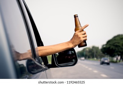 A Man's Hand Is Holding A Jar Of Alcohol While Driving In The Street, Driving Negligence.