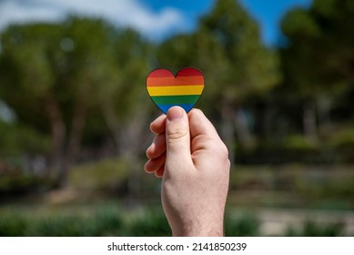  Man's Hand Holding Lgtb Rainbow Heart Sign  

