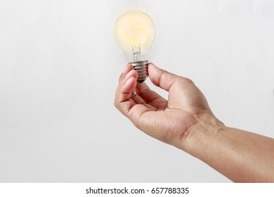 Man's hand holding an light  bulb  on white background with  concept for energy savings - Shutterstock ID 657788335