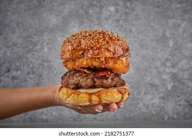A Mans Hand Holding A Meat Burger