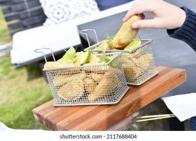 Man's Hand Holding A Meat Empanada, Served On A Frying Pan