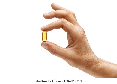 Man's hand holding Omega 3 capsule isolated on white background. Close up. High resolution product.