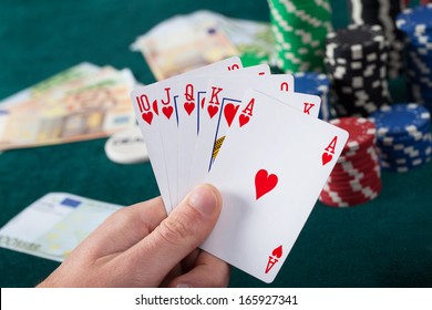 Man's Hand Holding Royal Flush In Poker Game