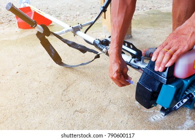 Man's Hand Is Holding Screwdriver For Carburetor Adjustment Of The Sash Mower