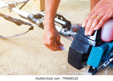 Man's Hand Is Holding Screwdriver For Carburetor Adjustment Of The Sash Mower