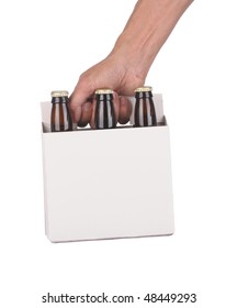 Man's Hand Holding A Six Pack Of Brown Beer Bottles Isolated Over A White Background