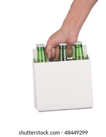 Man's Hand Holding A Six Pack Of Green Beer Bottles Isolated Over A White Background