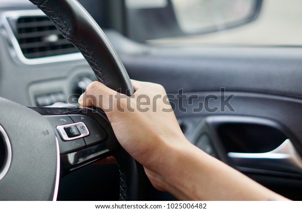 Man\'s hand holding\
steering wheel driving