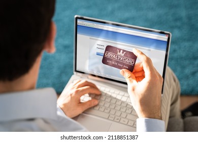 Man's Hand Holding VIP Member Card While Using Laptop