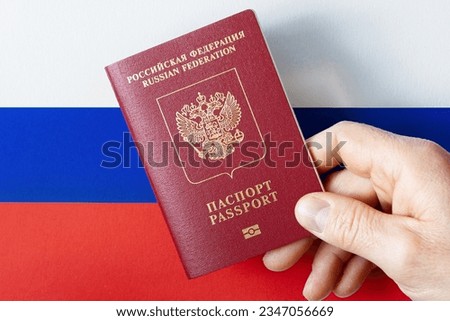 A man's hand holds a International passport of the Russian Federation on a background of national flag ストックフォト © 