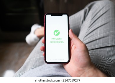 A Man's Hand Holds A Smartphone On Screen With The Message Money Sent And Received. Concept Of Financial Transactions With Mobile Devices. Closeup, Money, Transfer, Phone, Payment. Cafe Background
