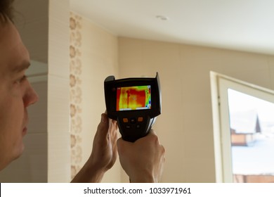 man's hand holds a thermal imager - checks the walls