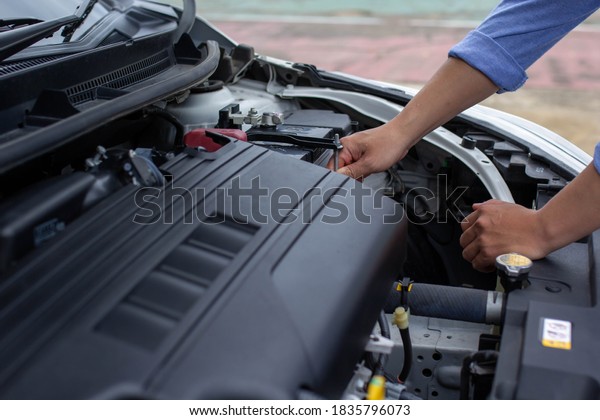 Man\'s hand is investigating the reason why his\
car crashed, car insurance\
concept.