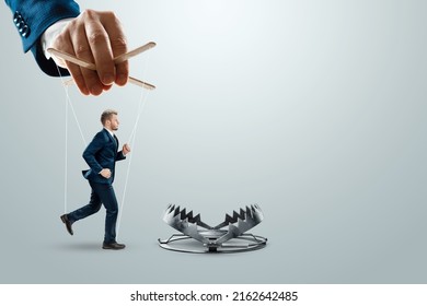 A man's hand leads a puppet into a trap. The concept of mortgage, dirty money, bribe, corruption, easy money, debt, credit. mixed media - Shutterstock ID 2162642485