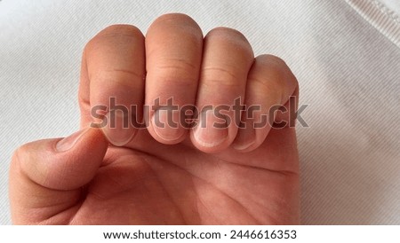 A man's hand with long uncut damaged nails. Unkempt nails of a man on a white background. Close-up