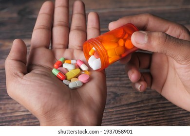 Man's Hand With Medicine Spilled Out Of The Pill Container 