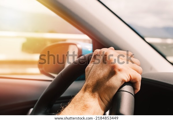 Man\'s hand on the steering wheel close-up, man\
driving a car
