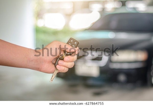 Man\'s\
hand open the car with car remote key at car\
park.