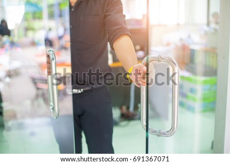 Man's hand open the door with glass reflection background