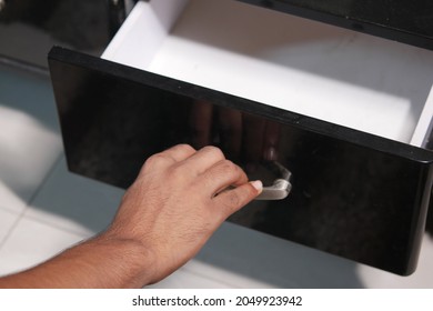 Man's Hand Open Drawer Wooden In Cabinet