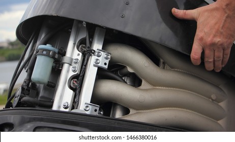 A Man's Hand Open The Hood Of A Powerful Boat Outboard Motor, Repair And Maintenance Of Watercraft Engines, A View Of The Intake Manifold Of A Four Cylinder Four Stroke Injector Motor