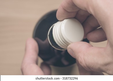 Man's Hand Opening A Screw Cap Of Red Wine Top View