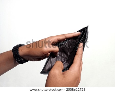 Man's hand opens empty black leather wallet without money. Bad economic concept, financial crisis, risk at the end of the month. Financial management. Salary. Debt. Bankrupt. Financial problems