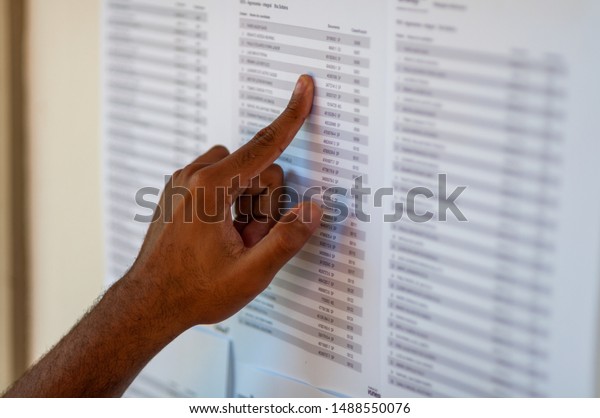 man-s-hand-pointing-to-a-name-list-trying-to-find-some-name