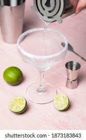 Man's Hand Pouring Drink Into A Cocktail Glass. Margarita Preparation