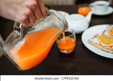 Man's Hand Pouring Orange Juice Into A Glass Close-up