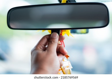 Man's hand presses adjusting rearview mirror dimming. Selective focus.