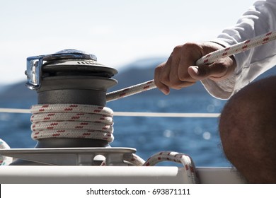 Mans Hand Pulling Winch Rope On Sailing Boat