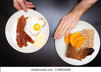 Mans Hand Pushing Away A High Carb Plate Of Food In Favor Of A High Fat Ketogenic Diet Plate Of Food.