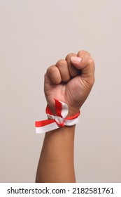 Man's hand with red white ribbon as indonesian flag symbol - Shutterstock ID 2182581761