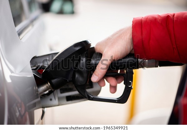 man\'s hand is refuelling gas or oil\
in the refuelling station prepare transport to\
travel
