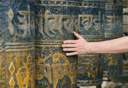 Man's Hand Spins Nepalese Prayer Wheels, Close-up View