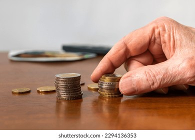 Man's hand stacking european coins on the table. Closeup. - Powered by Shutterstock