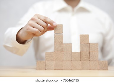 Man's Hand Stacking Wooden Blocks. Business Development Concept 