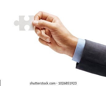 Man's Hand In Suit Holding One Puzzle Element Isolated On White Background. Close Up. High Resolution Product