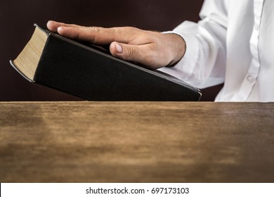 Man's Hand Swearing On The Bible. Taking An Oath. 