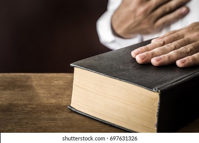 Man's Hand Swearing On The Bible. Taking An Oath. 