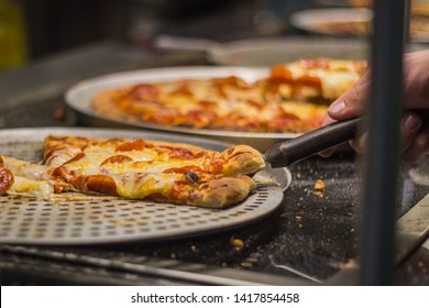 Man's Hand Takes A Slice Of Pizza On A Buffet