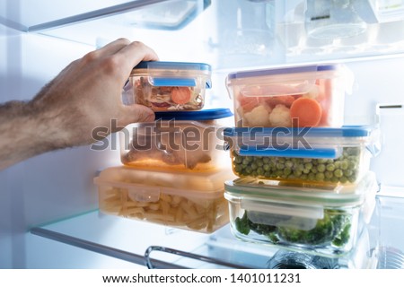 Man's Hand Taking Container Of Frozen Mixed Vegetables From Refrigerator