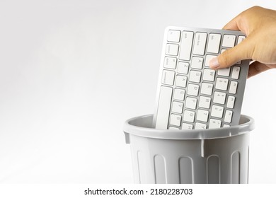 A man's hand throwing a keyboard in the trash. Image of digital detox