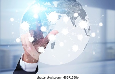 Man's Hand Touching A Screen With Globe And Startup Icons. Concept Of International Trade.Toned Image. Double Exposure