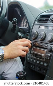 Man's Hand Tuning Radio In The Car.