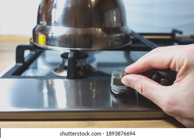 Man's Hand Turn On The Gas Stove In The Kitchen.