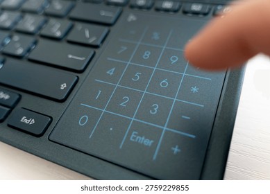 Man's hand typing on Numeric keypad of the black computer keyboard. Close-up. the finger presses the numbers on the keyboard. Electronic numpad on a black laptop. - Powered by Shutterstock - Get 15% off with code: PIKWIZARD15