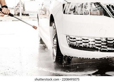 A Man's Hand Washes His White Car At The Sink. Soap Suds On A Car